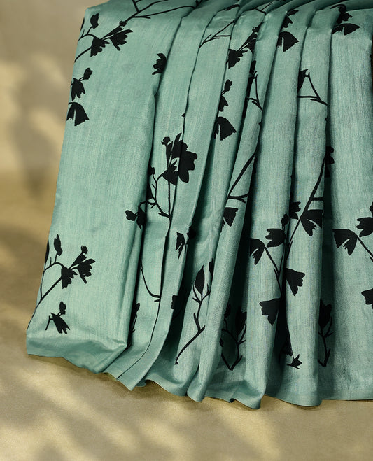 Pastel aqua colour semi printed saree featuring black florak kodi prints across the body, finished with a sleek plain border, with matching blouse