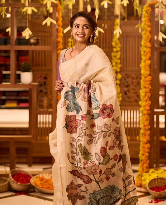 Off White colour Kerala saree beautifully adorned with Kalamkari applique floral work motifs in multicolour across the body and pallu, complemented by a subtle plain border, paired with a matching blouse