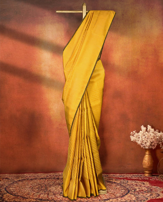 Yellow colour pure Mayuri silk saree featuring finely woven Golden zari motifs across the body, detailed with a subtle geometric self border with intricate texture, with matching blouse