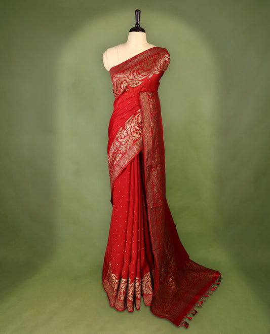 Red colour pure Tussar Banaras saree adorned with delicate golden zari motifs on the body, rich floral woven zari border and grand pallu, paired with a matching blouse for an elegant and regal traditional look.