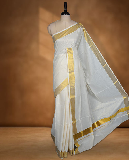 Off white colour Kerala cotton saree featuring fine golden stripes, complemented by a classic zari border and traditional pallu, paired with a matching blouse.