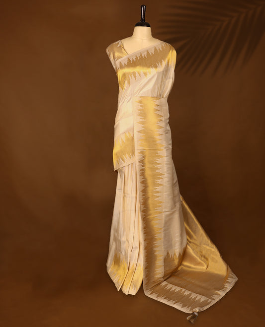 Ivory and gold soft tissue Kerala saree featuring a striking zigzag zari border with a matching blouse