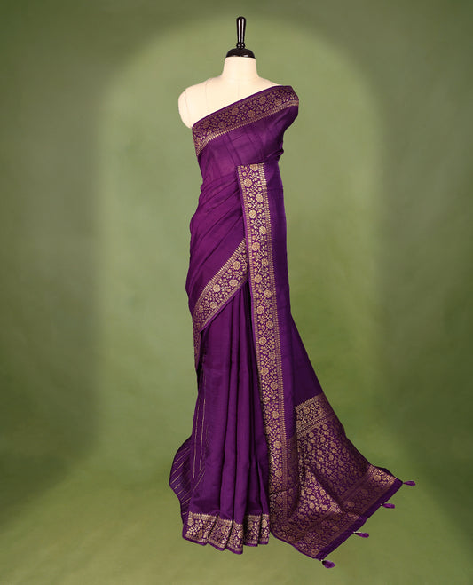 Purple colour Tussar Banaras saree featuring a plain body, rich floral woven zari border and grand pallu, paired with a matching blouse for an elegant and regal traditional look.