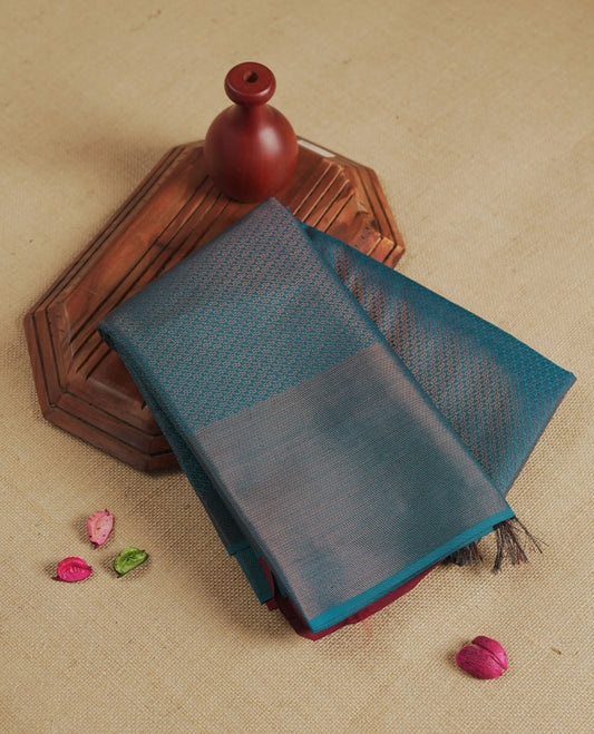 Deep aqua blue colour semi silk saree featuring neem zari Brocade Pattern all over the body, complemented by a Self Colour woven border with detailing with contrast Maroon Colour Pallu & blouse.