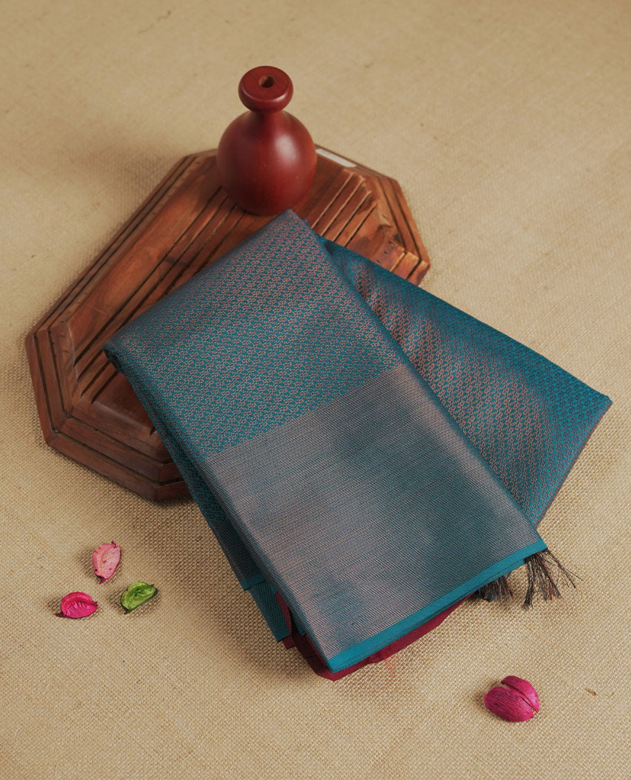 Deep aqua blue colour semi silk saree featuring neem zari Brocade Pattern all over the body, complemented by a Self Colour woven border with detailing with contrast Maroon Colour Pallu & blouse.