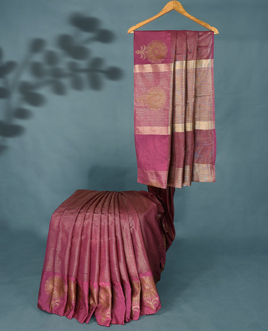 Dark Onion Pink Colour Semi Tussar Silk saree featuring golden zari horizontal lines across the body, adorned with bold Floral motifs on the border, paired with a matching blouse.