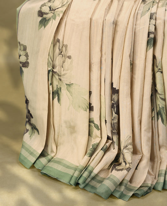 Cream colour semi silk printed saree adorned with soft green floral motifs across the body, finished with a light green striped border, with matching blouse