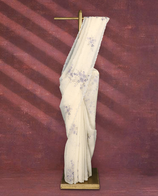 White colour pure organza saree featuring Lavender floral prints with intricate bead and sequin work across the body, adorned with a matching embellished border, complemented by a worked pallu and paired with a heavily worked matching blouse.