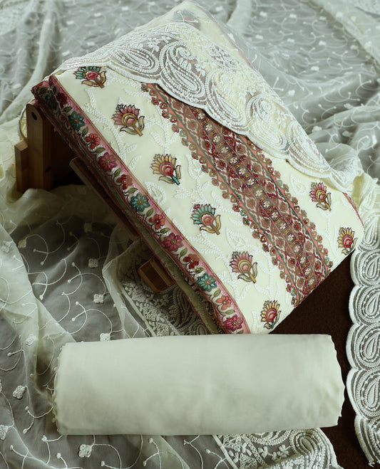 Cream colour churidhar material with embroidered neck work, white threadwork on the body, and multicolor floral motifs in pink, green & yellow & Comes with matching plain bottom and embroidered dupatta.
