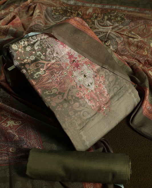 Earthy olive green colour churidhar material featuring intricate embroidery with subtle paisley patterns, paired with a richly printed dupatta and plain bottom.