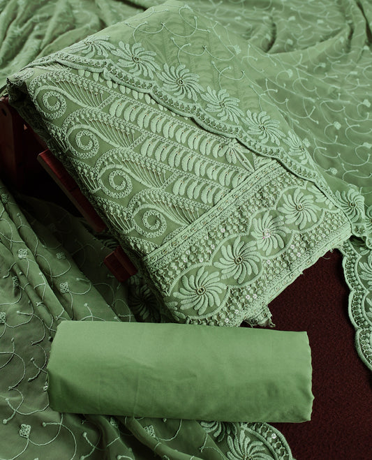 Elegant pastel green churidhar material adorned with intricate floral embroidery and delicate sequin highlights, paired with a plain matching bottom and embroidered dupatta, perfect for festive celebrations and graceful occasions.