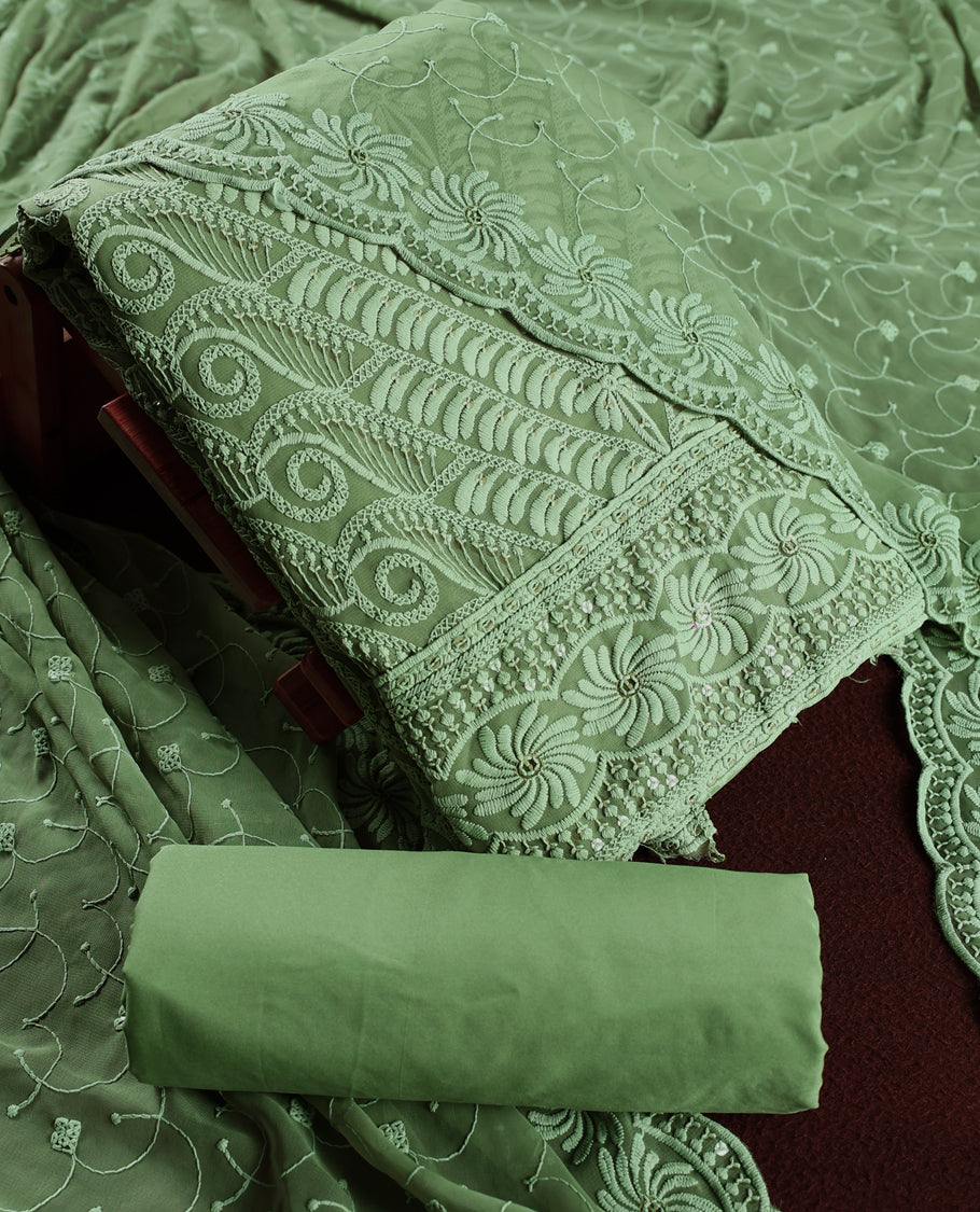 Elegant pastel green churidhar material adorned with intricate floral embroidery and delicate sequin highlights, paired with a plain matching bottom and embroidered dupatta, perfect for festive celebrations and graceful occasions.