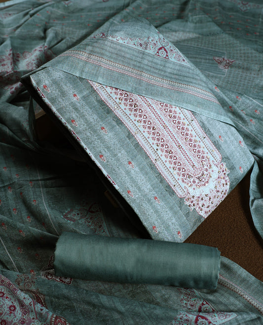 Pastel green colour churidhar material with intricate thread embroidery and sequin highlights, paired with a plain matching bottom and a soft printed dupatta for a subtle yet elegant ethnic ensemble.