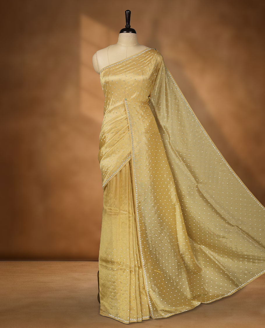 Coral Peach colour net shimmer fancy saree adorned with white stone buttas all over the body, paired with a delicate stone worked border, with matching blouse