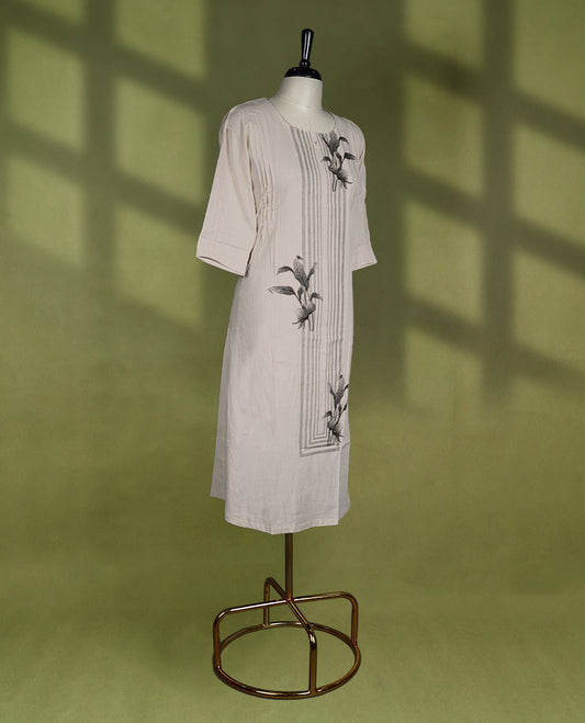 Off white colour kurti featuring a round neckline and three quarter sleeves, enhanced with vertical panel stitch detailing and minimal floral prints