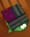 Grape and Green Kalyani cotton saree adorned with delicate buttas across the body, complemented by intricately woven golden zari patterns on the border and pallu, paired with a matching blouse