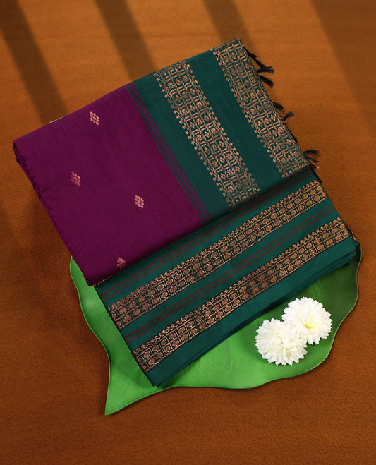 Grape and Green Kalyani cotton saree adorned with delicate buttas across the body, complemented by intricately woven golden zari patterns on the border and pallu, paired with a matching blouse