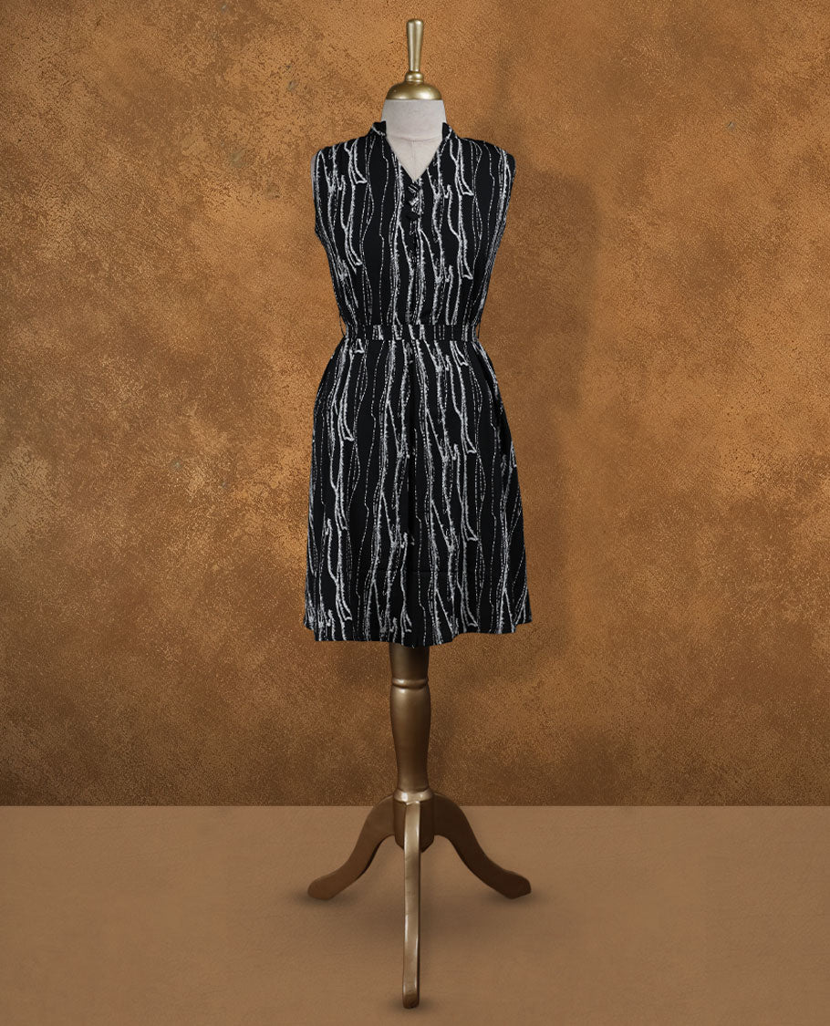 Black sleeveless knee-length shirt dress with abstract white wavy print, band collar, front button placket, and elasticated waistline