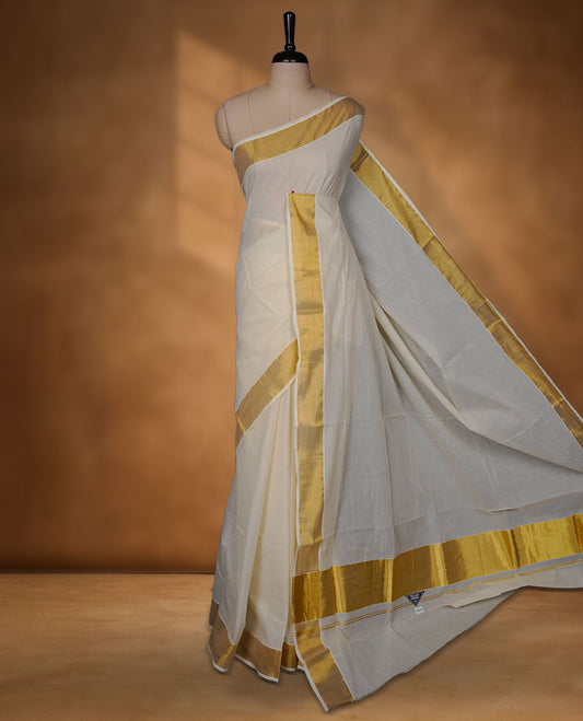 Off-white colour cotton Kerala saree crafted in a soft, sheer weave, finished with a classic rich gold kasavu border along the body and pallu, and paired with a matching blouse.