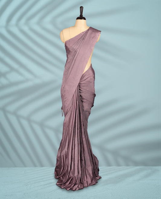 Pastel mauve colour semi silk saree features a subtle checked body design with a sleek plain border, and comes with a matching blouse