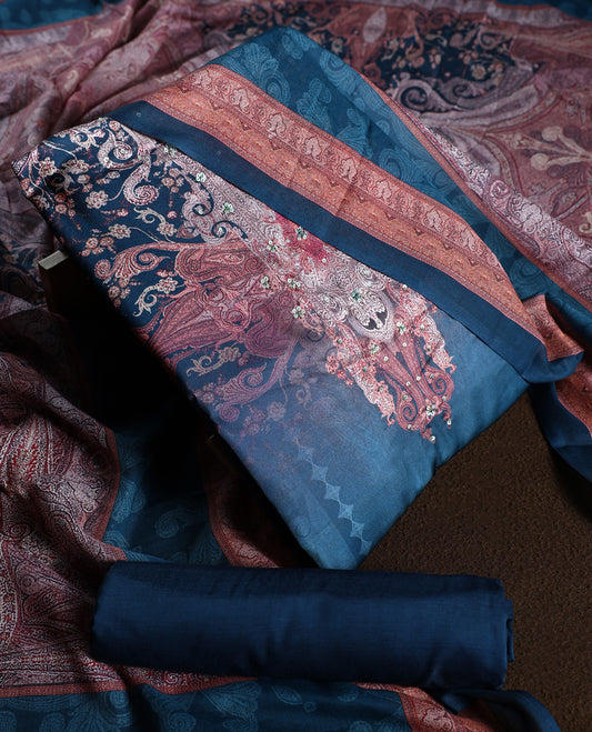 Dark peacock blue colour churidhar material with subtle paisley motifs, sequin highlights, and woven border design, paired with a plain matching bottom and a soft printed dupatta for a graceful ethnic look.