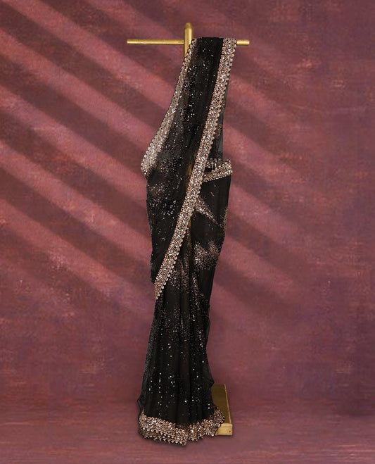 Black colour net designer saree embellished with all over shimmering sequin work in diagonal patterns and a heavily sequined border, exuding glamour and elegance, paired with a matching worked blouse for a striking look