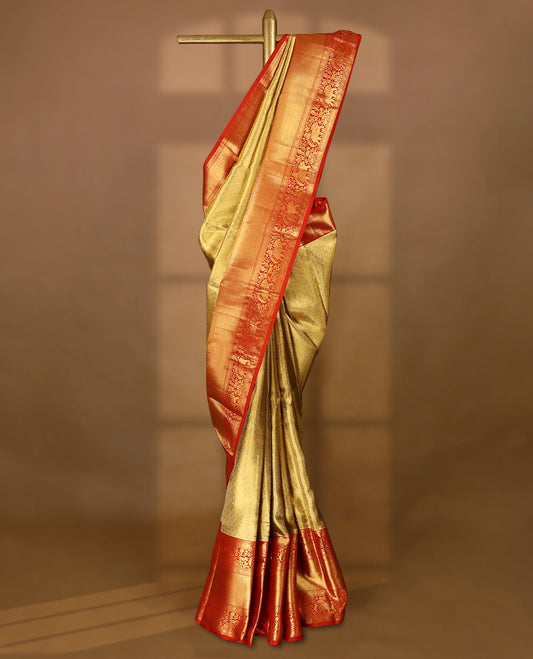 Gold Colour Kancheepuram tissue silk saree featuring an intricately woven antique zari jacquard design on the body, elegantly complemented by a bright red traditional border with elephant, bird, and Rudraksham motifs, and paired with a matching blouse.