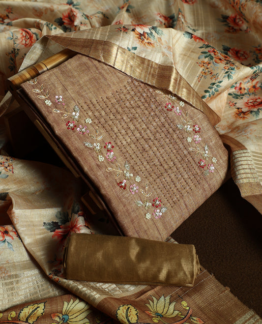 Flaxen yellow colour churidhar material adorned with floral embroidery and sewn glass beads on the yoke, paired with a plain bottom and same colour dupatta featuring floral prints.