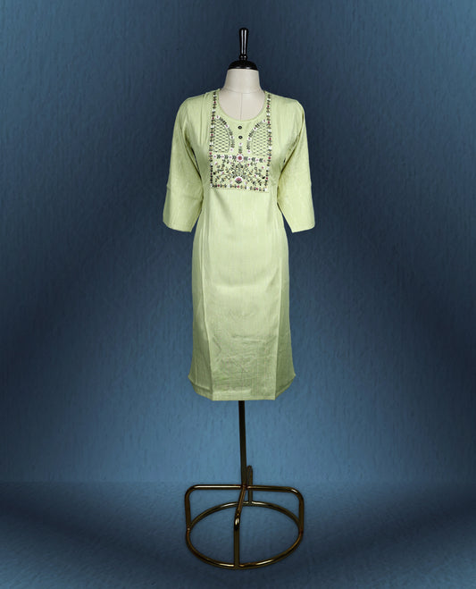 Light green colour kurti with subtle vertical self stripes, highlighted by an intricately embroidered yoke in floral and geometric patterns, featuring a round neckline with button accents and three quarter sleeves.