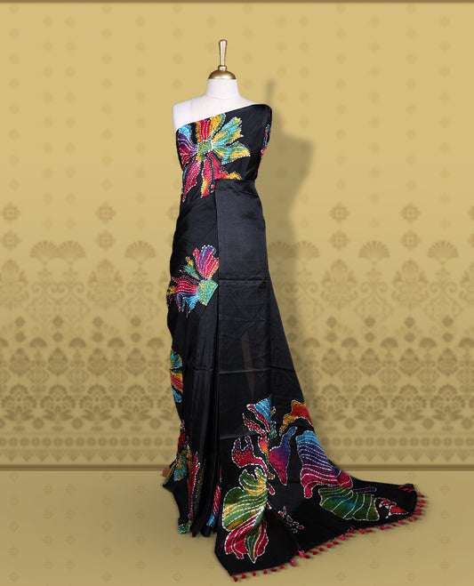 Black colour semi khadi silk saree adorned with yellow, green and magenta colour bold floral motifs across the body, designed without a border for a contemporary touch, and paired with a matching blouse.