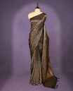 Black colour semi Banaras Katan saree featuring an antique Gold zari jacquard body, complemented by a self colour traditional border with a floral kodi design, paired with a matching blouse