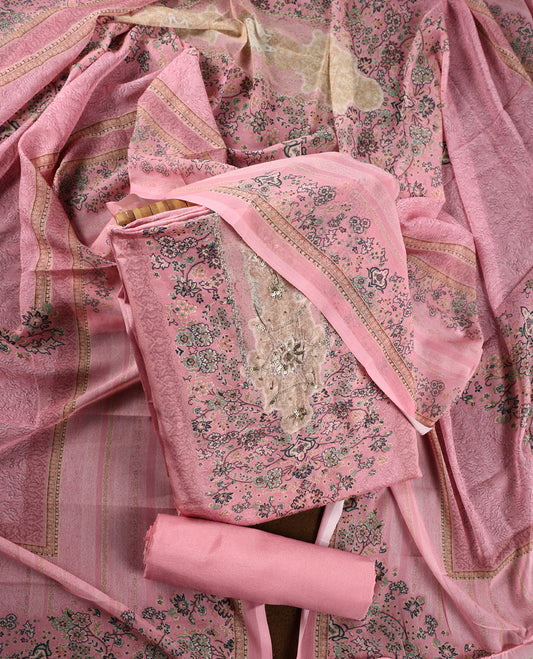Pink colour churidhar material featuring delicate floral prints and intricate embroidery on the neckline, paired with a matching printed dupatta and a plain bottom.