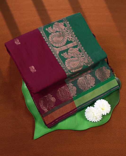 Maroon and Bottle Green Kalyani cotton saree adorned with traditional peacock motifs, enhanced by a rich woven zari border and pallu in green, paired with a matching blouse.