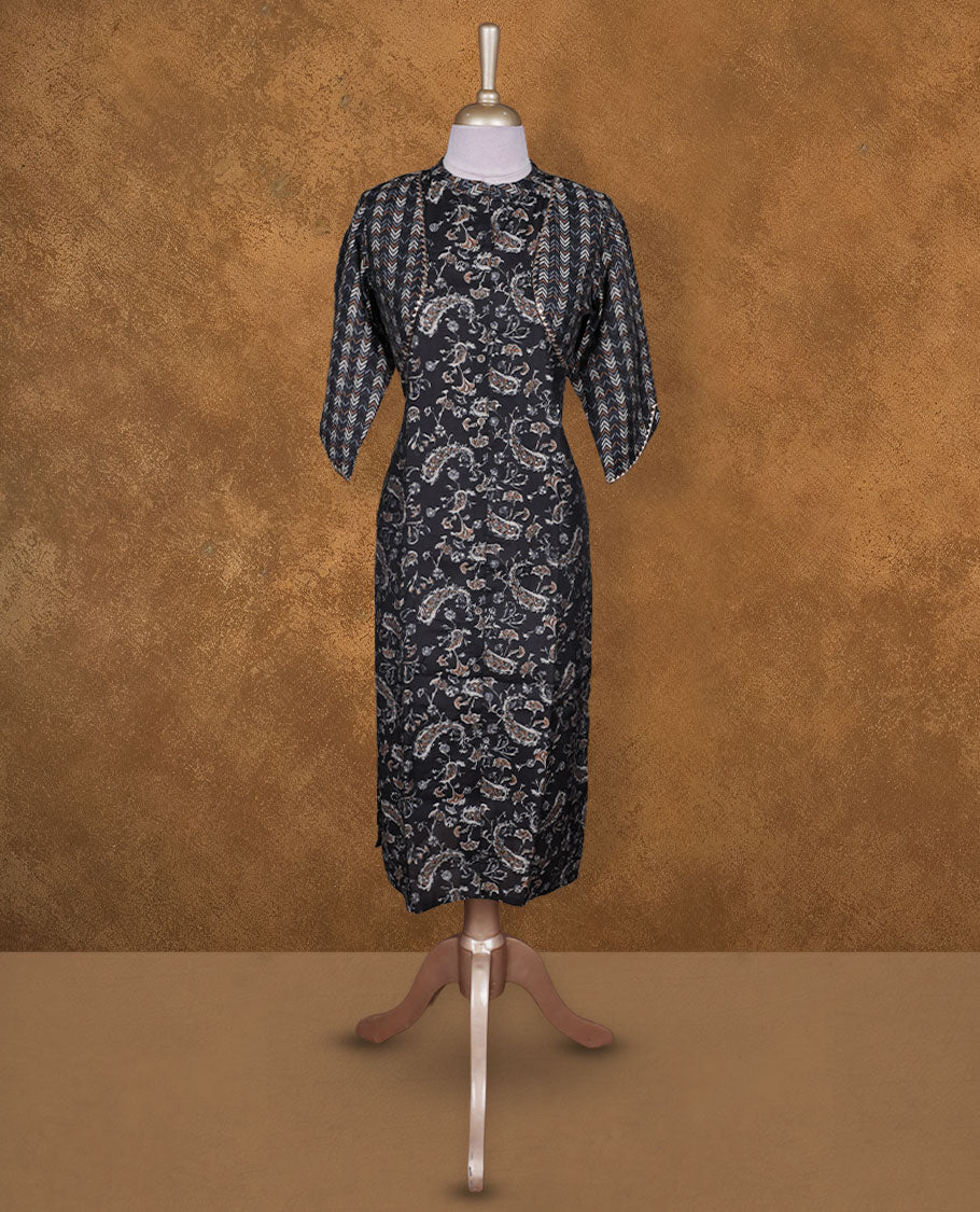 Black colour printed kurti by Talisha with all‑over paisley motifs, attached chevron shrug‑style layer, straight calf‑length silhouette, round neckline, and elbow‑length sleeves.