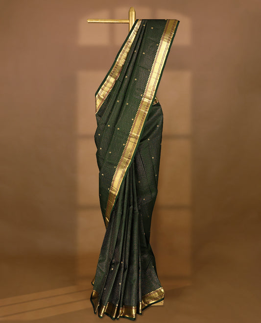 Dark green Colour traditional Kancheepuram silk saree adorned with an antique zari grid pattern and small golden Floral motifs on the body, featuring a border with paisley and Rudraksham motifs, and paired with a matching blouse.