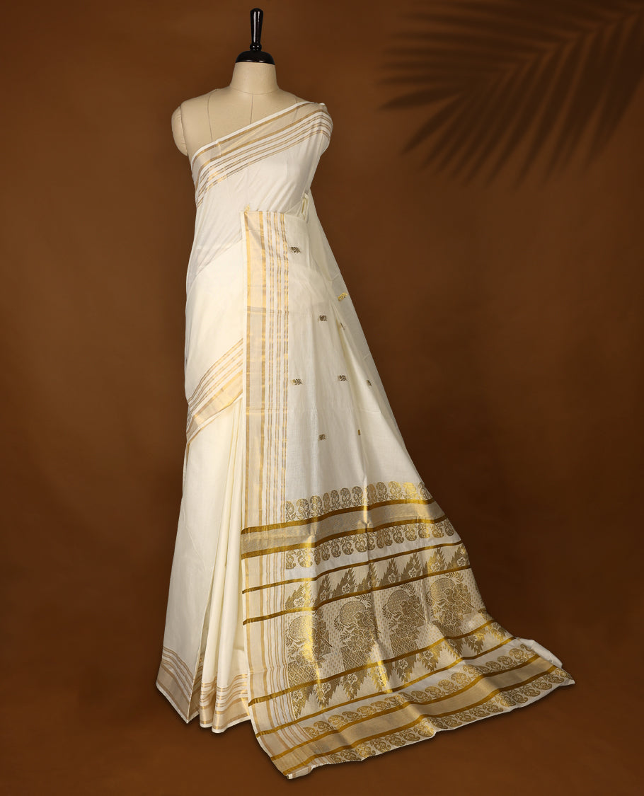 Elegant Off white colour cotton Kerala saree featuring Plain body, Gold zari fancy kazavu border, Rich Pallu paired with matching blouse.