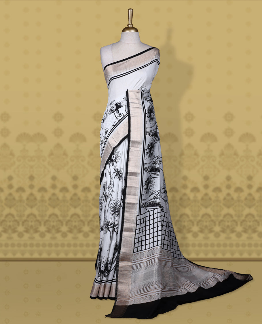White colour saree with black floral and geometric prints, featuring a contrast zari border and beautifully detailed printed pallu & Comes with a matching blouse piece.
