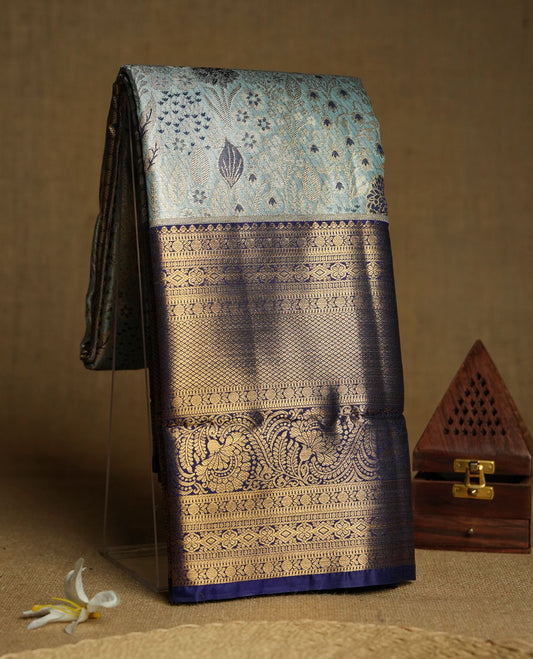 Aqua blue colour and Antique gold Zari Tissue Brocade Saree features intricate floral Motifs on body and navy blue colour border & pallu with traditional patterns paired with matching blouse