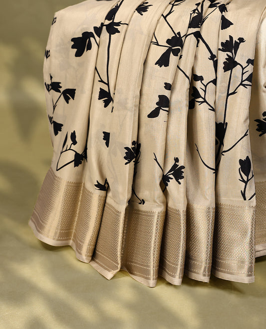 Beige colour semi printed saree featuring black florak kodi prints across the body, finished with a Golden Zari border, with matching blouse