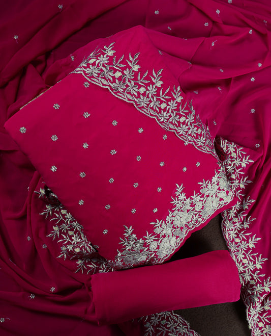 Pinkish red colour churidhar material adorned with elegant golden floral embroidery and delicate motifs, paired with a matching embroidered dupatta and plain bottom.