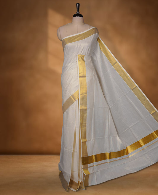Off-white colour cotton Kerala saree featuring a classic gold kasavu border, detailed with fine woven stripes across the body and pallu, and paired with a matching blouse.