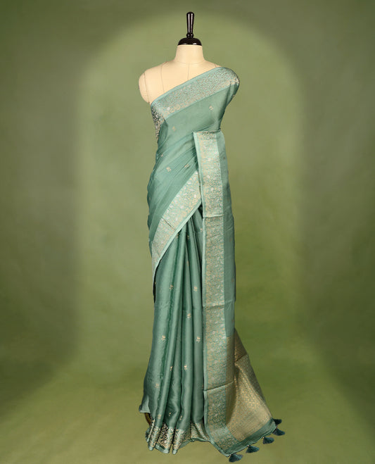 Pastel Green colour pure Banaras crepe saree showcases elegant Gold zari Flower Motifs all over the body, a traditional gold & Silver zari border, a rich intricately woven pallu, and comes with a matching blouse.