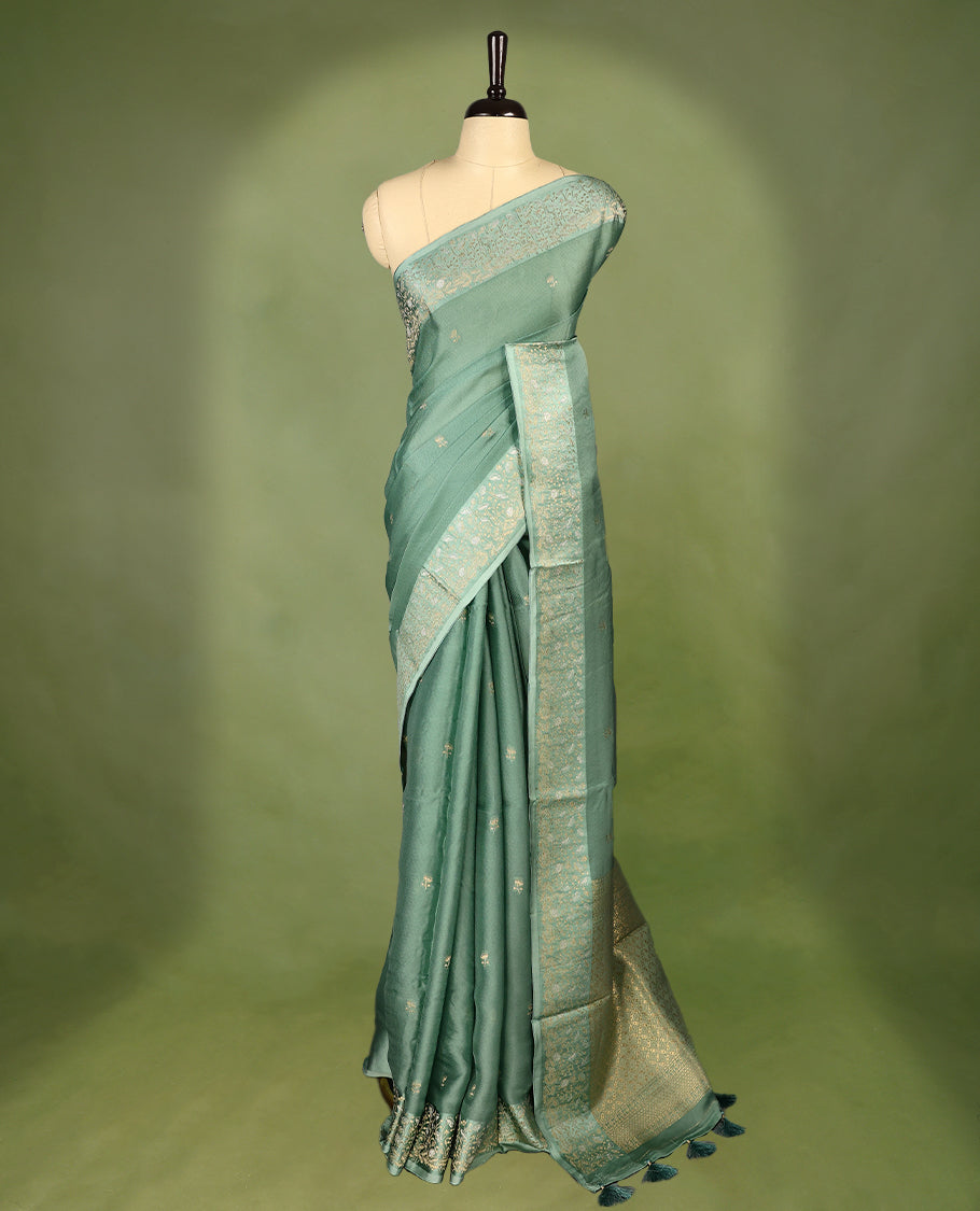 Pastel Green colour pure Banaras crepe saree showcases elegant Gold zari Flower Motifs all over the body, a traditional gold & Silver zari border, a rich intricately woven pallu, and comes with a matching blouse.