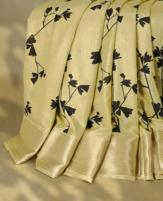 Light pastel mustard green colour semi printed saree featuring black florak kodi prints across the body, finished with a Golden Zari border, with matching blouse