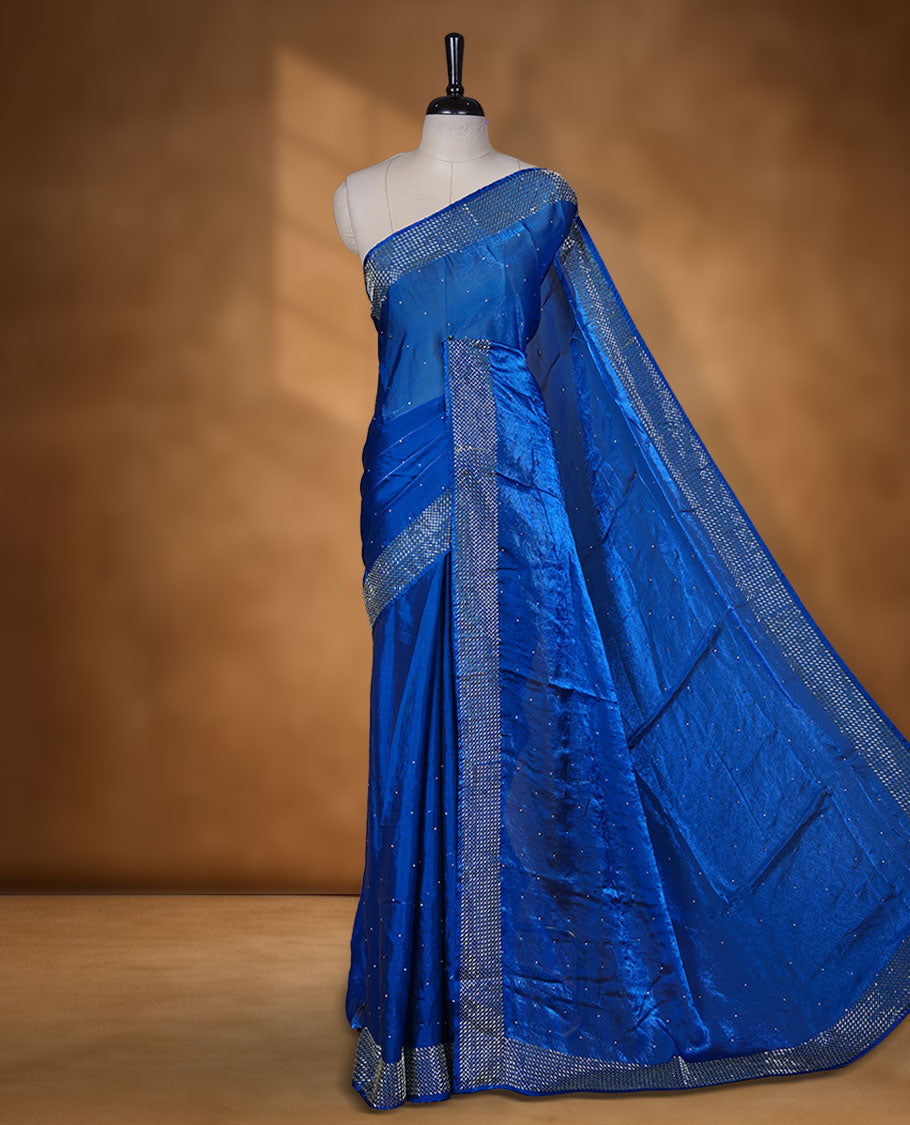 Royal Blue colour chiffon designer saree, featuring dainty scattered stones on the body, enriched with dense stone work and a heavy metallic stone border and pallu, paired with a matching blouse.