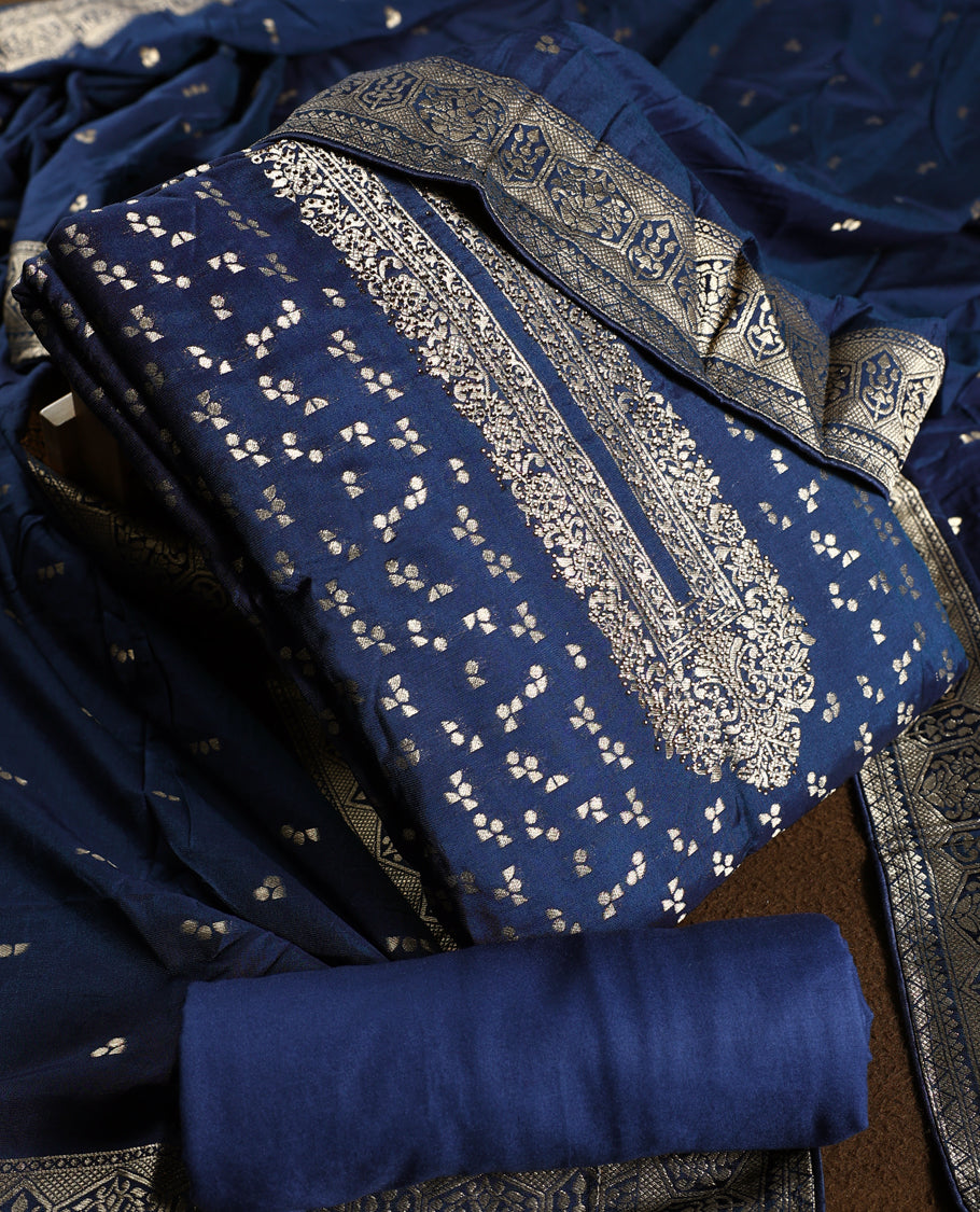 Regal navy blue churidhar material embellished with golden zari floral motifs and an ornate woven border, paired with a plain matching bottom and grand dupatta, perfect for weddings, festive occasions, and royal celebrations.