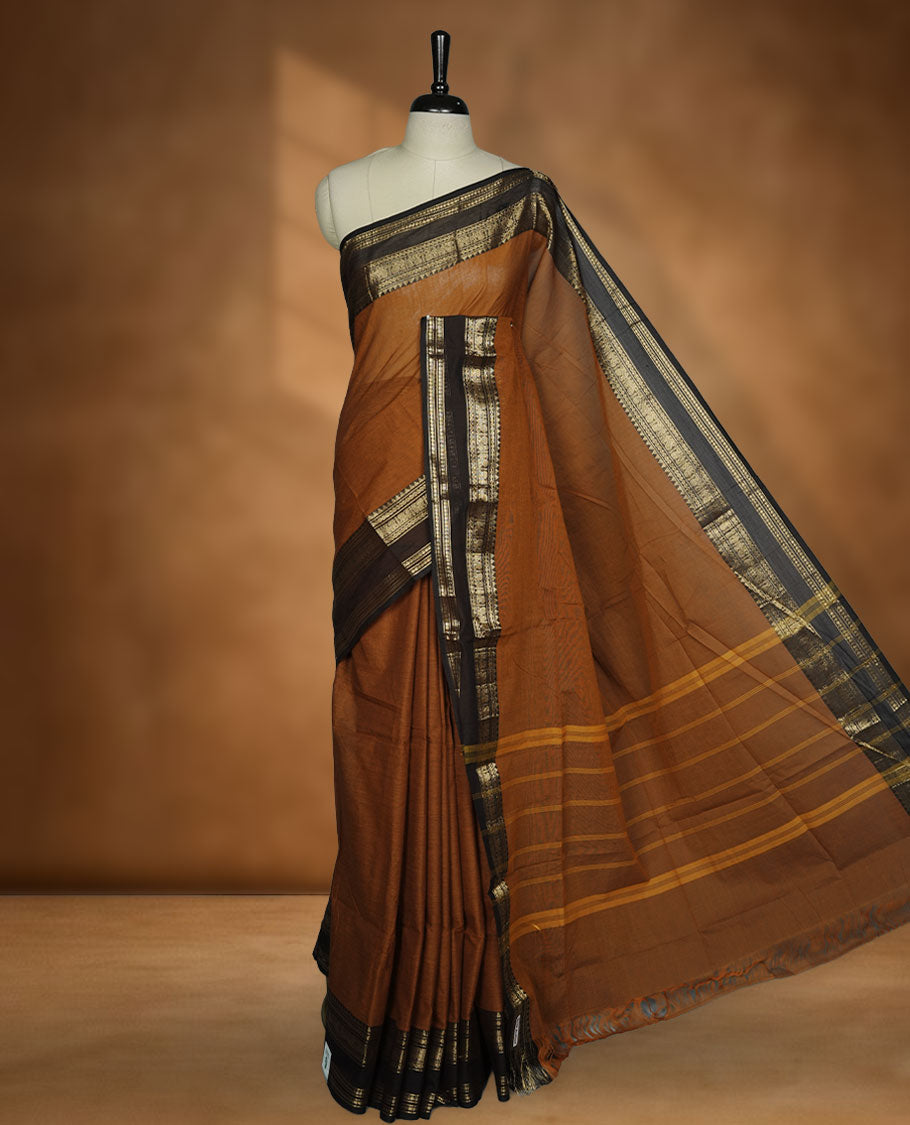 Burnt orange colour chettinad cotton saree featuring plain body, contrast Chocolate brown colour with traditional gold zari border paired with matching blouse.