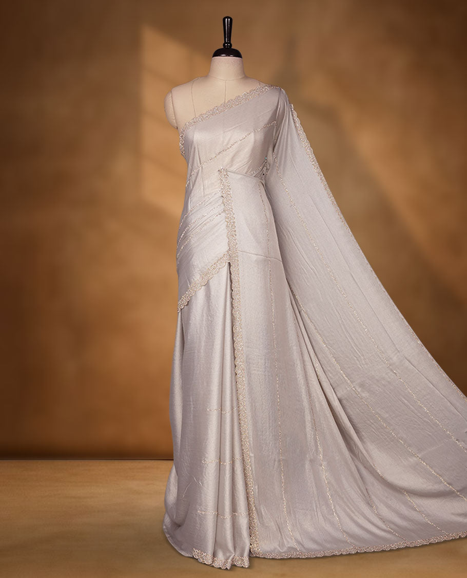 Silver Pink colour net shimmer fancy saree adorned with scattered white stone buttas, paired with a delicate stone worked border and matching blouse.