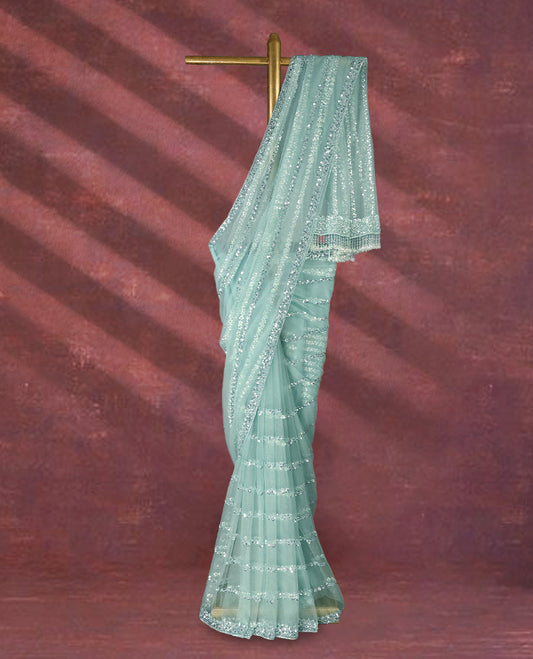 Pastel mint green colour net designer saree adorned with shimmering sequin stripes all over and a sequin embellished border with beaded tassel detailing on the pallu, paired with a matching worked blouse for a chic festive look