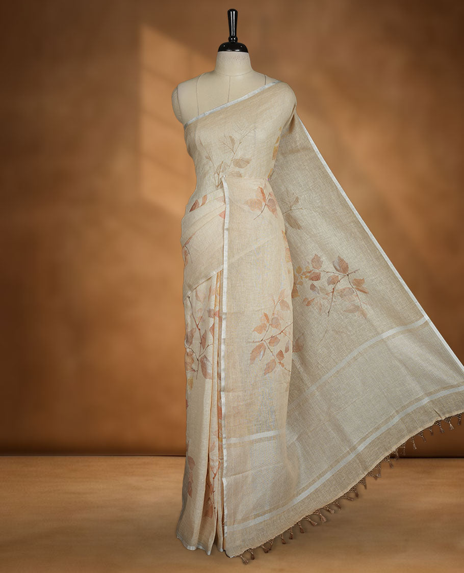 Beige colour pure linen saree featuring leaf print pattern across body, silver thin border finished with matching blouse.